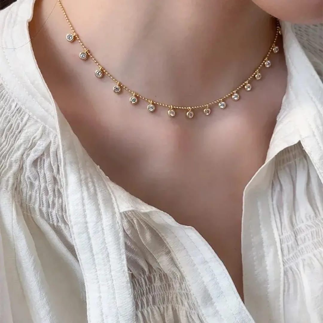Gold necklace with small beads on a person wearing a white blouse Goldess Jewelley 18k pure gold plated necklace trending