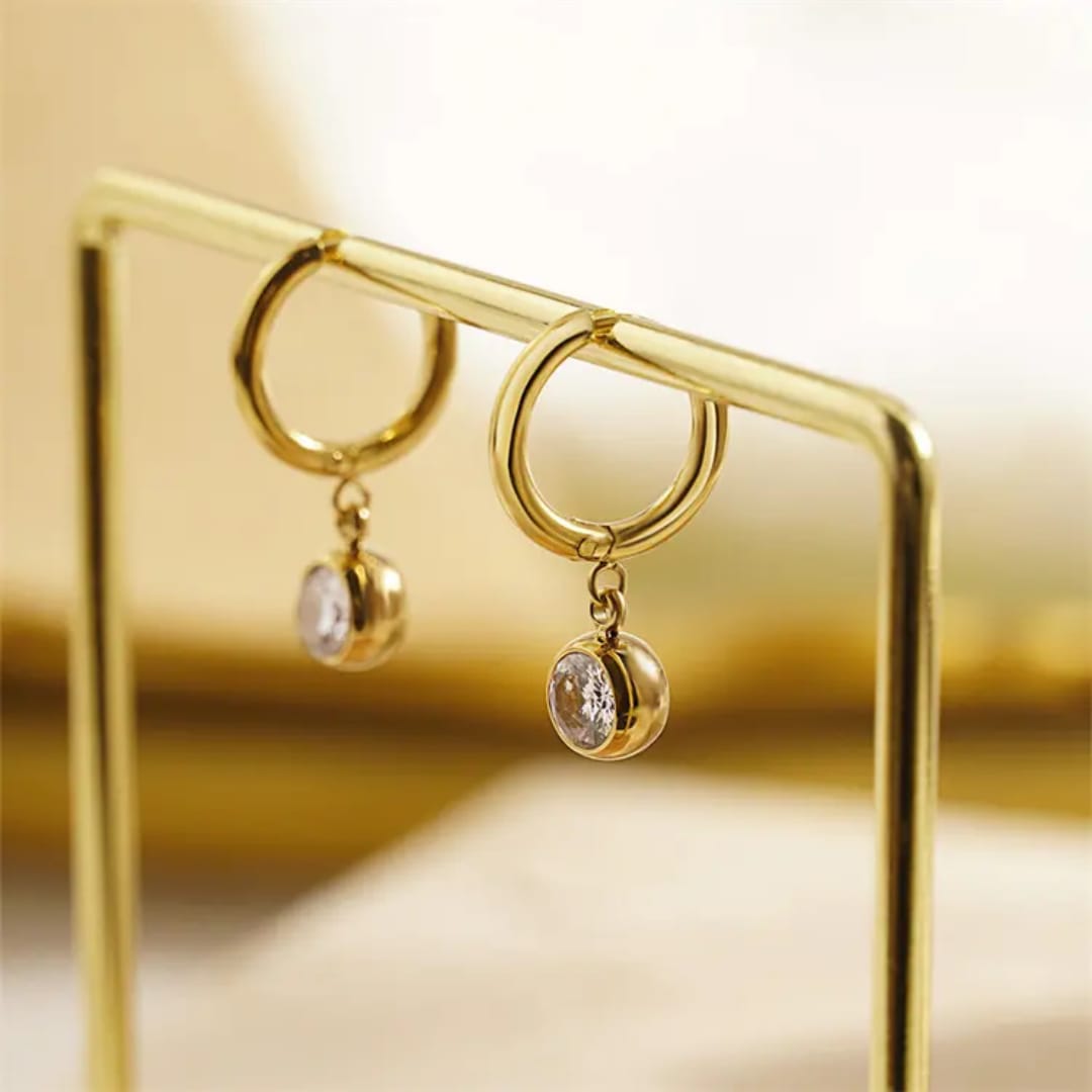 Gold hoop earrings with small round charms on a gold stand. Goldess Jewelley demi fine 18 k gold plated pvd