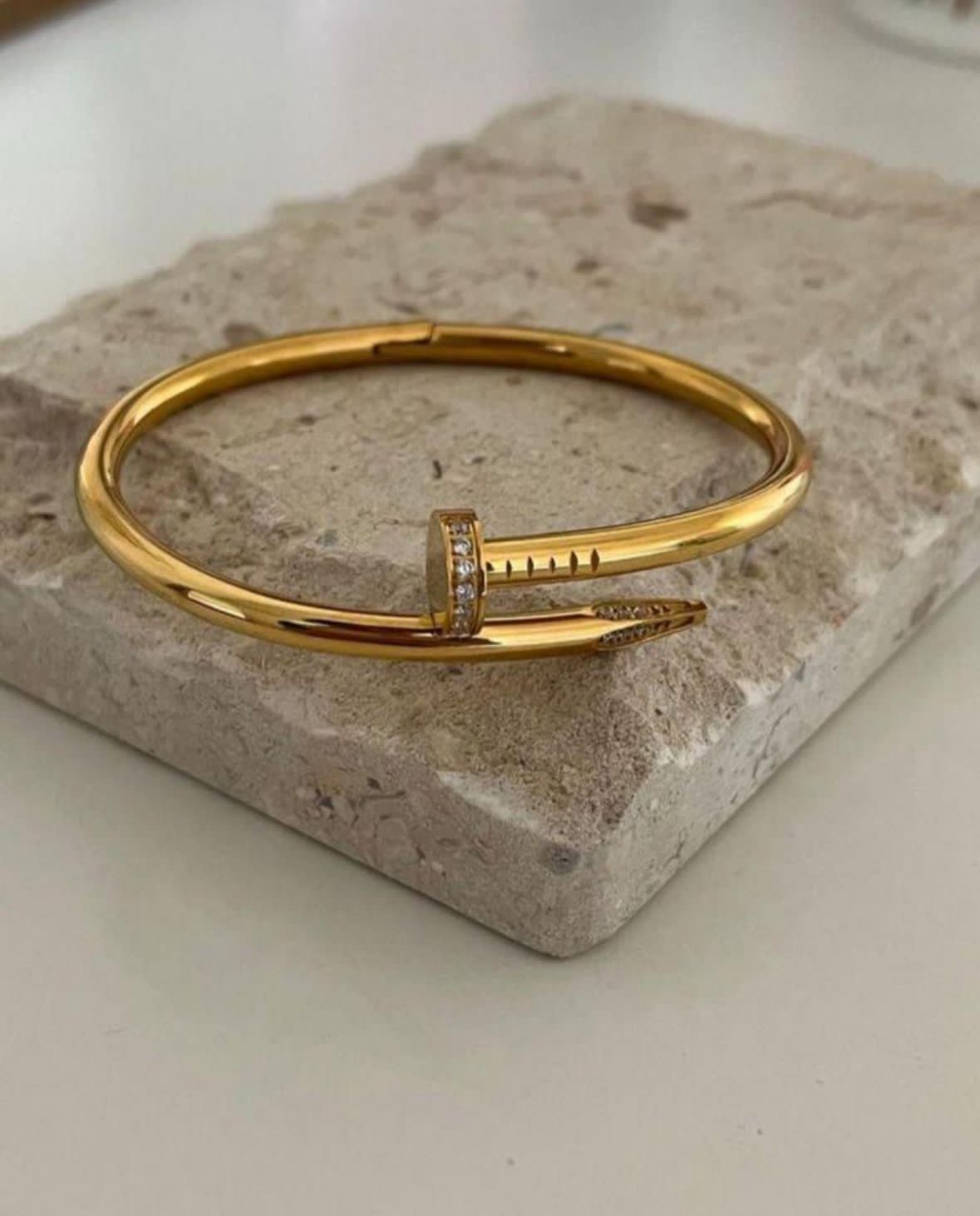 Gold bracelet on a stone surface