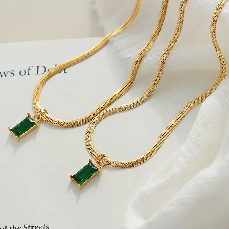 Gold necklace with green pendants on a light background Goldess_Jewellry_18k_pure_gold_plating_chain_with_pvd_technoloty