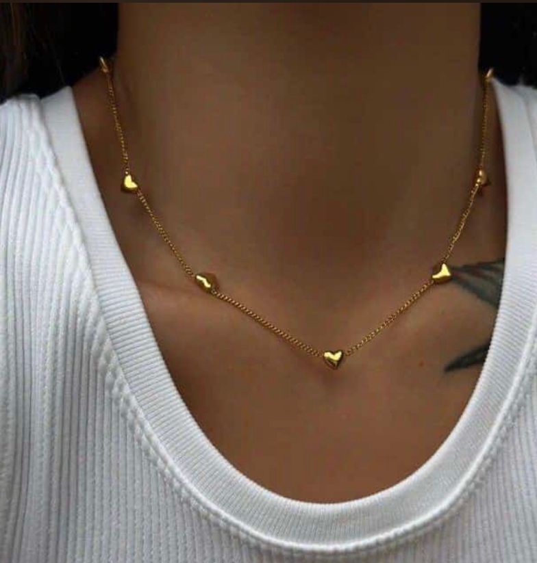 Gold necklace with heart pendants worn by a person on a white background Goldess Jewellry with pvd plating technology which last 10 times than normal jewelley 22
