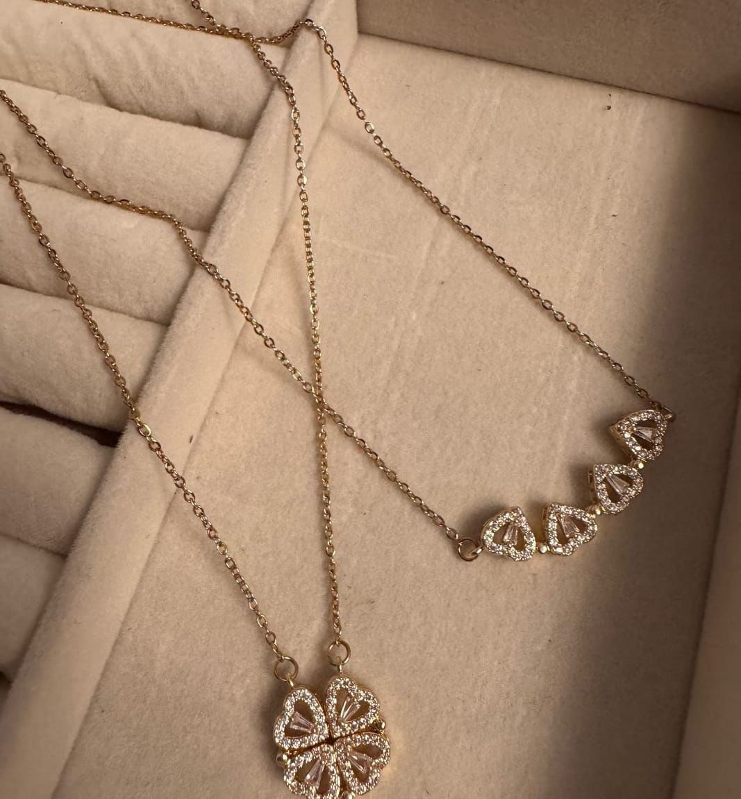 Gold necklace with diamond pendants on a textured beige surface The everyday grace necklace 18k pure gold plated