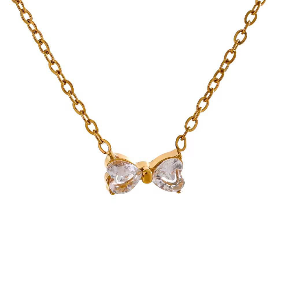 Gold bow-shaped necklace with clear stones on a white background goldess jewellery 18k gold plated pvd technlogy