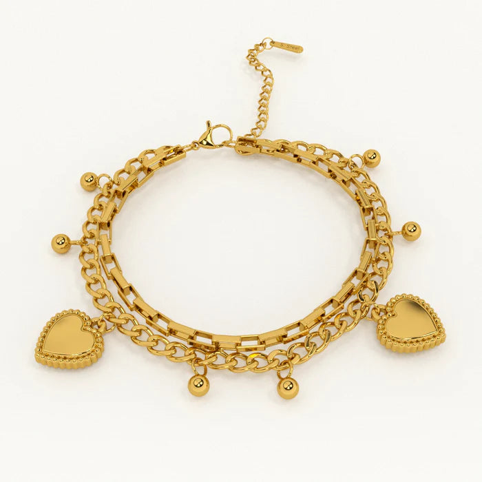 Gold bracelet with heart charms on a white background