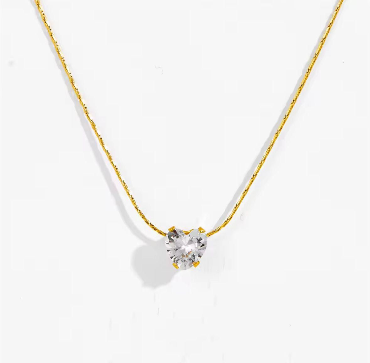 Gold necklace with a heart-shaped diamond pendant on a white background Goldess Jewellery gold plated jewelley with pvd technology