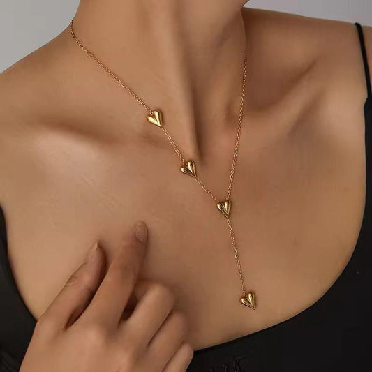 Gold necklace with heart pendants on a person wearing a black top. Goldess Jewellry pure 18k gold plated jewellery which last forever