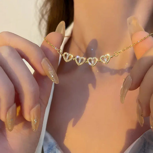 Gold heart-shaped bracelet on a wrist with a blurred background The everyday grace necklace 18k pure gold plated