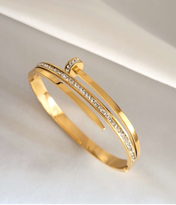 Gold bracelet with diamond accents on a light gray background